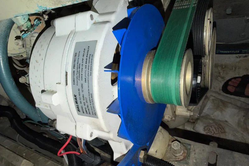 Slide: The Image of Alternator with blue pulley and green belt in a 1988 Monk 36 boat engine. - 31