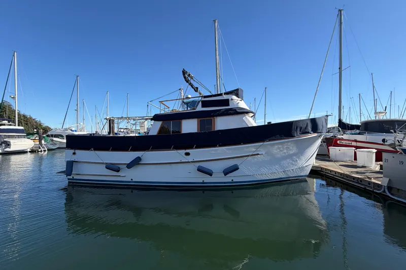 The Image of 1988 Monk 36 boat docked at marina under clear blue sky. - 0
