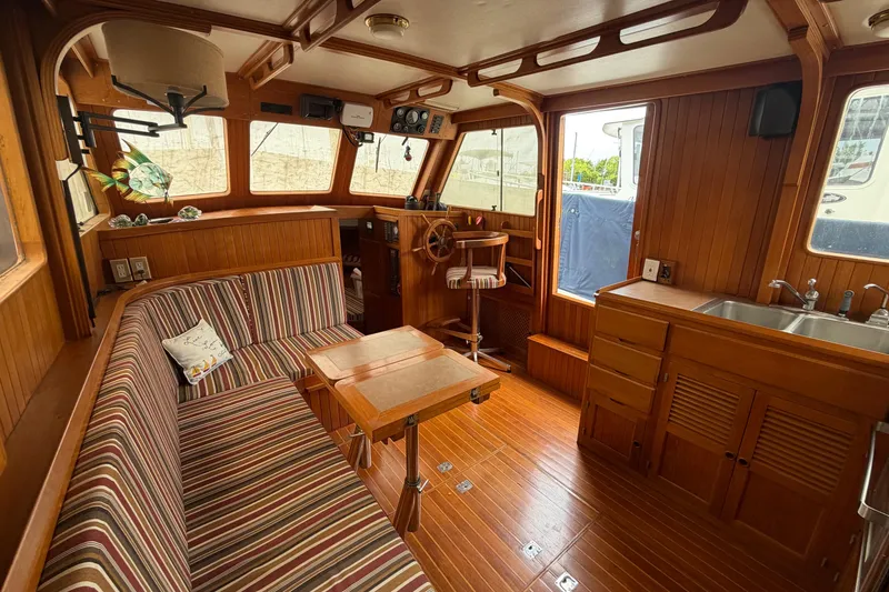 Slide: The Image of Interior of a 1988 Monk 36 boat with wood paneling and striped seating. - 9