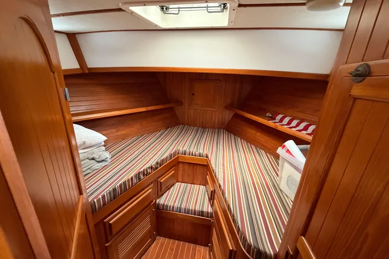 Slide: The Image of Cozy cabin interior of 1988 Monk 36 boat with striped bedding and wooden finish. - 12