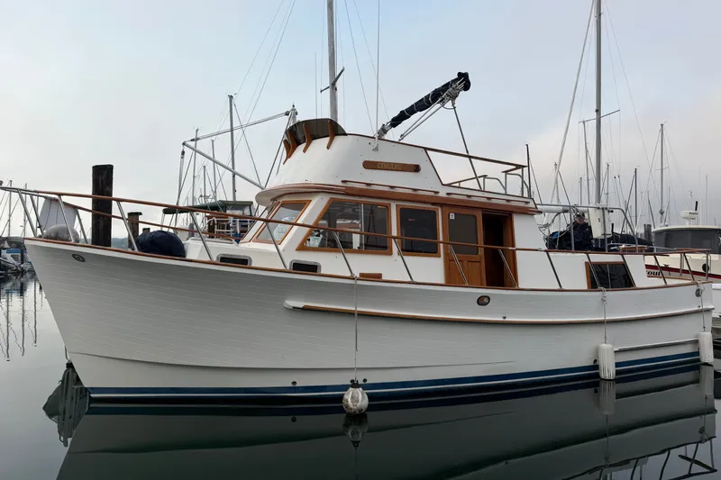 The Image of 1988 Monk 36 boat docked in a marina, featuring classic wooden design and white hull. - 0
