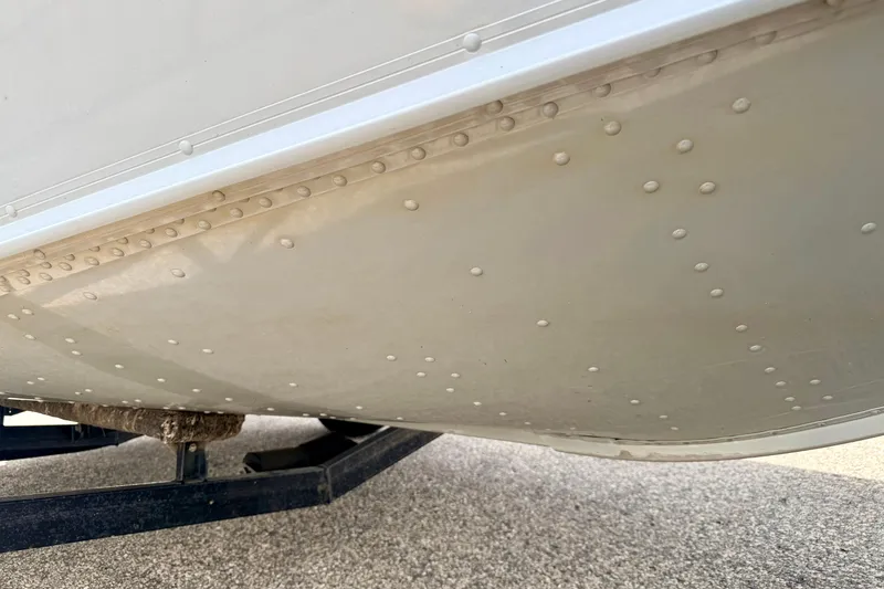 Slide: The Image of Close-up of 2003 Lund 1675 Adventure SS boat hull with rivets and trailer. - 14
