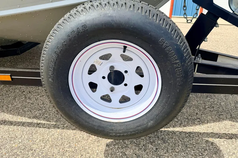 Slide: The Image of Trailer tire of a 2003 Lund 1675 Adventure SS boat on pavement. - 16