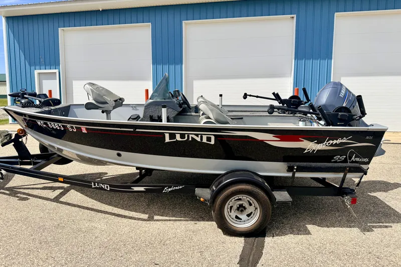 Slide: The Image of 2003 Lund 1675 Adventure SS boat on trailer, parked outside blue building. - 3