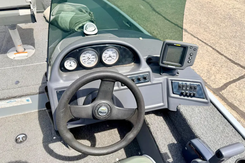 Slide: The Image of Dashboard of a 2003 Lund 1675 Adventure SS boat with steering wheel and gauges. - 35