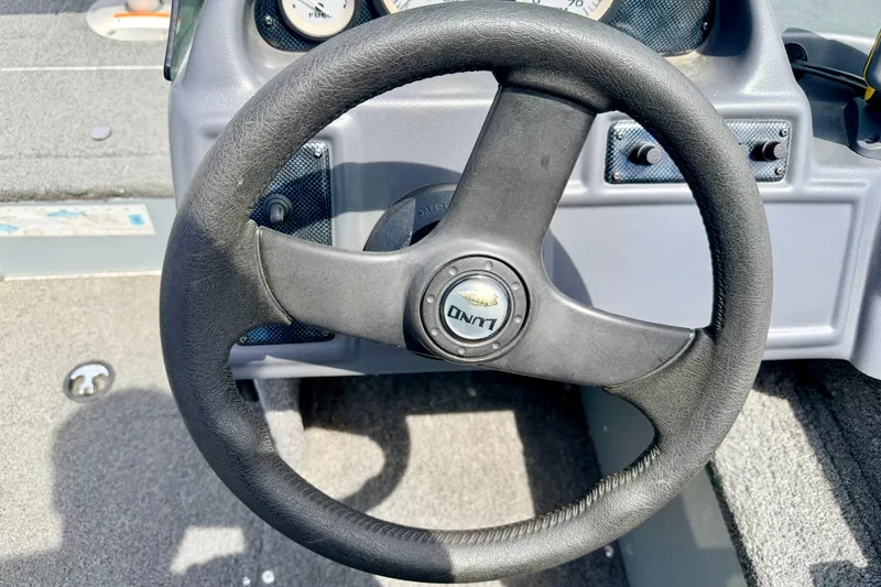 Slide: The Image of Steering wheel of a 2003 Lund 1675 Adventure SS boat, featuring dashboard controls. - 37