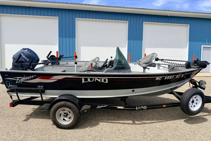 Slide: The Image of 2003 Lund 1675 Adventure SS boat on trailer, parked outside blue building. - 4