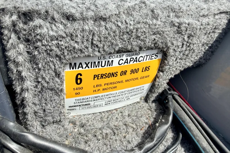 Slide: The Image of U.S. Coast Guard capacity label on 2003 Lund 1675 Adventure SS boat, showing limits. - 43