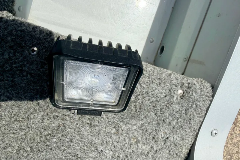 Slide: The Image of LED light fixture on carpeted surface of 2003 Lund 1675 Adventure SS boat. - 66