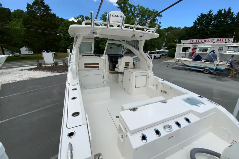 Slide: The Image of 2026 Pursuit DC 286 Dual Console boat at dealership, showcasing spacious deck and seating. - 12