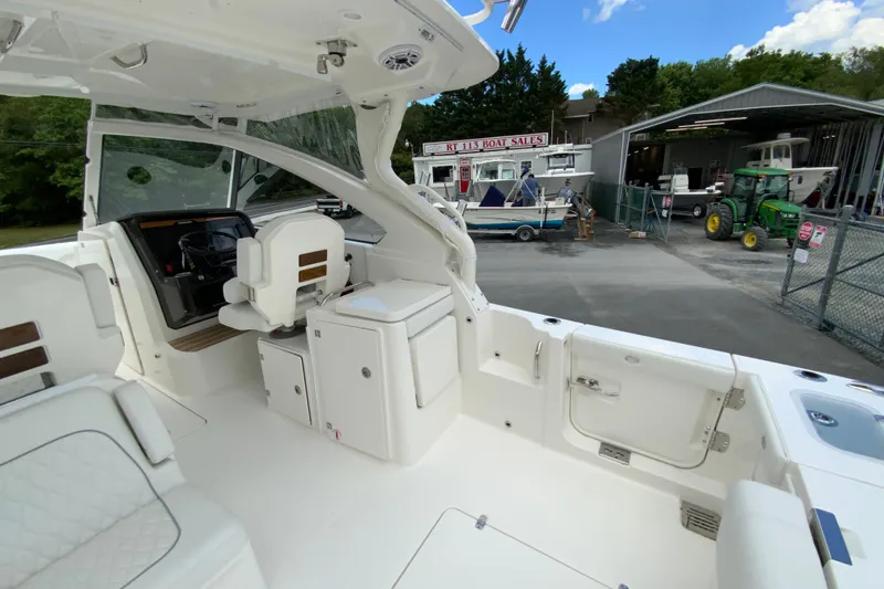 Slide: The Image of 2026 Pursuit DC 286 Dual Console boat interior at a dealership, showcasing seating and helm. - 13