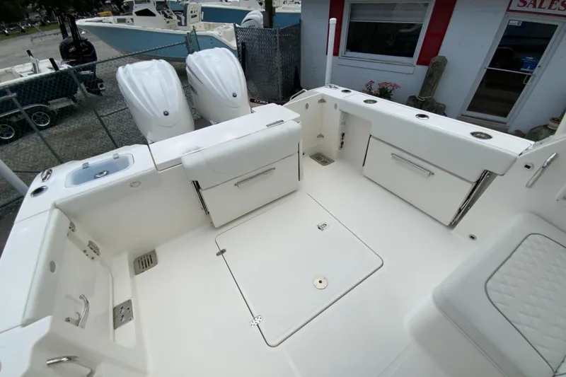 Slide: The Image of 2026 Pursuit DC 286 Dual Console boat interior with storage compartments and twin engines. - 15