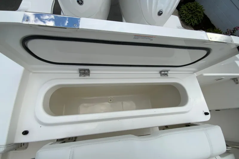 Slide: The Image of Open storage compartment on 2026 Pursuit DC 286 Dual Console boat. - 17