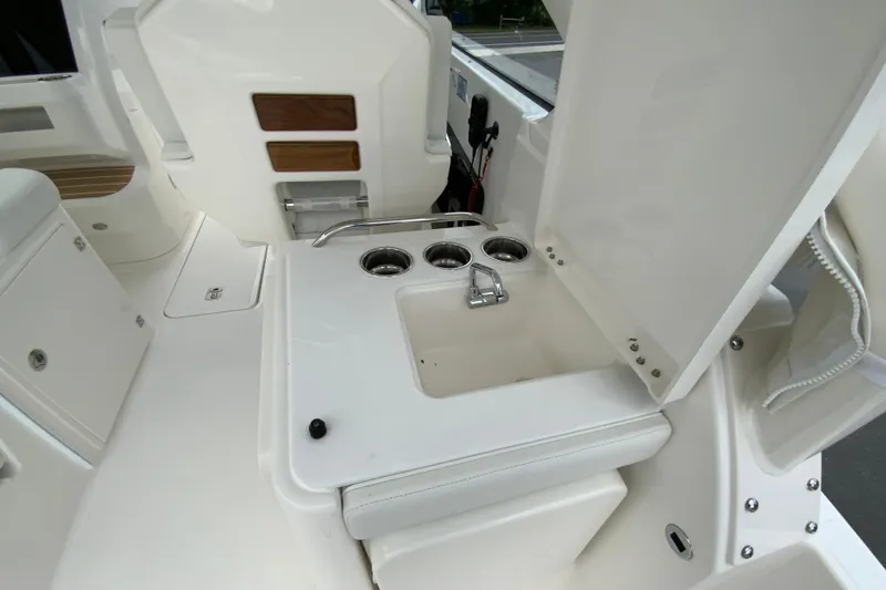Slide: The Image of 2026 Pursuit DC 286 Dual Console boat interior with sink and seating area. - 21