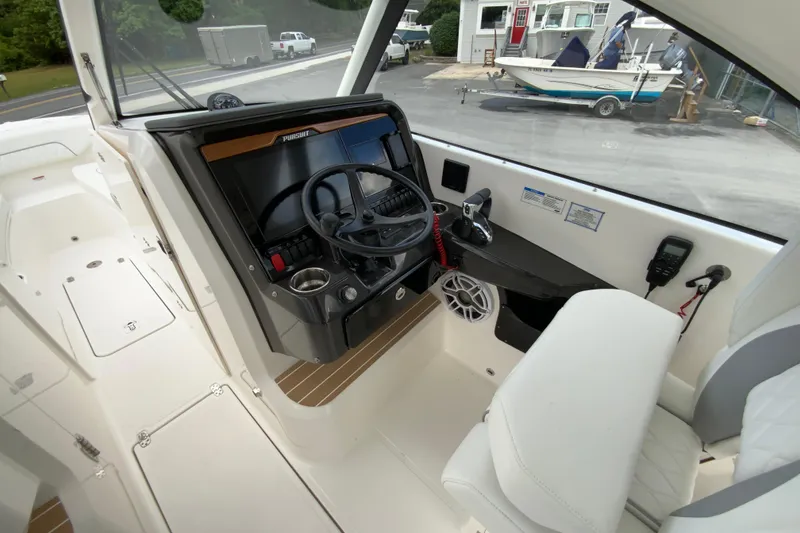 Slide: The Image of 2026 Pursuit DC 286 Dual Console boat cockpit with steering wheel and controls. - 24