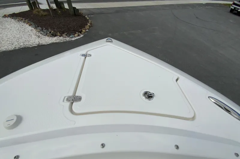 Slide: The Image of Bow of 2026 Pursuit DC 286 Dual Console boat, featuring sleek design and storage hatch. - 31