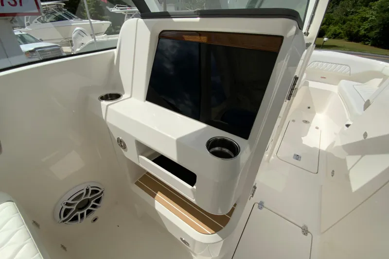 Slide: The Image of 2026 Pursuit DC 286 Dual Console boat interior with sleek dashboard and cup holders. - 34
