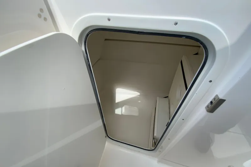 Slide: The Image of 2026 Pursuit DC 286 Dual Console boat storage compartment, open hatch view. - 36