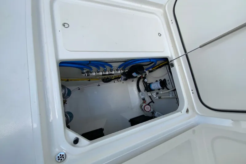 Slide: The Image of 2026 Pursuit DC 286 Dual Console boat compartment with visible wiring and plumbing. - 39