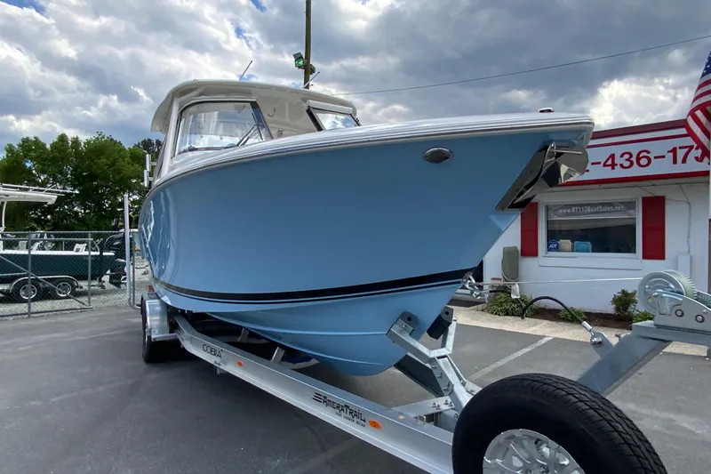 Slide: The Image of 2026 Pursuit DC 286 Dual Console boat on trailer, displayed outdoors under cloudy sky. - 4