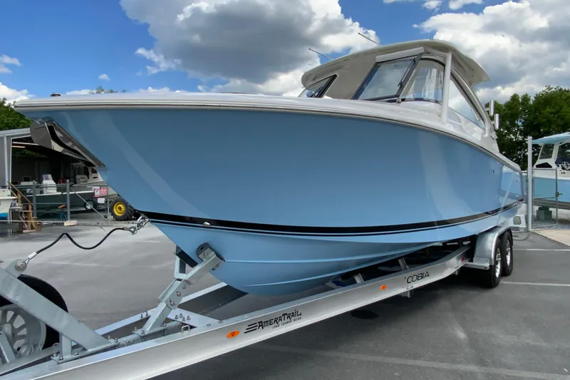Slide: The Image of 2026 Pursuit DC 286 Dual Console boat on trailer under cloudy sky. - 6