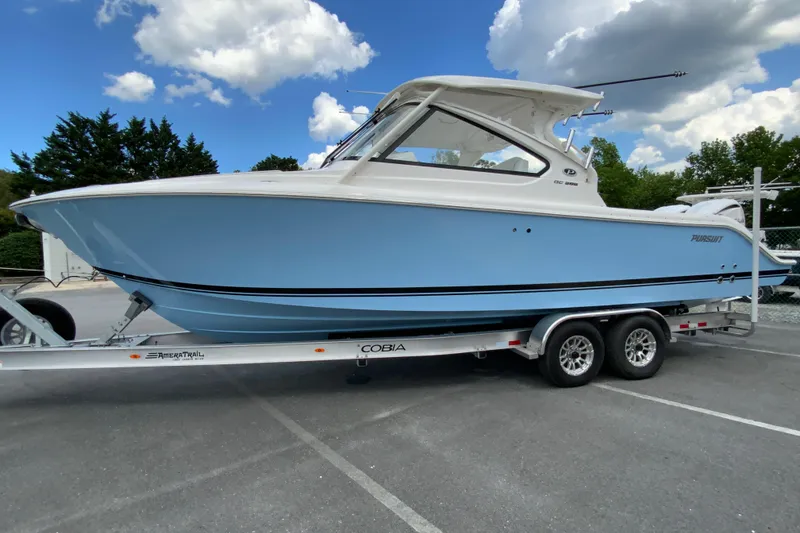 Slide: The Image of 2026 Pursuit DC 286 Dual Console boat on trailer under blue sky. - 7