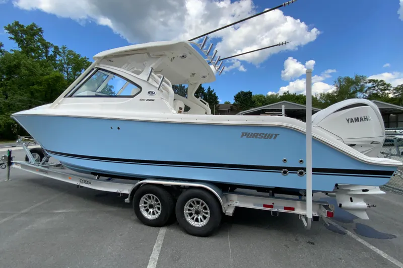 Slide: The Image of 2026 Pursuit DC 286 Dual Console boat on trailer, featuring Yamaha engines. - 8