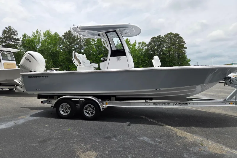 Slide: The Image of 2026 Sportsman Masters 247 Bay Boat on trailer, parked outdoors with trees in background. - 5