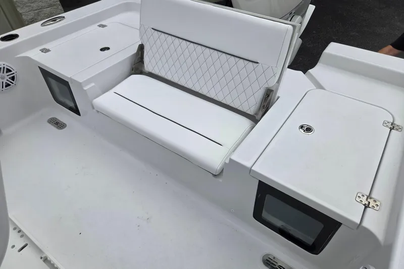 Slide: The Image of 2026 Sportsman Masters 247 Bay Boat interior with white seating and storage compartments. - 9