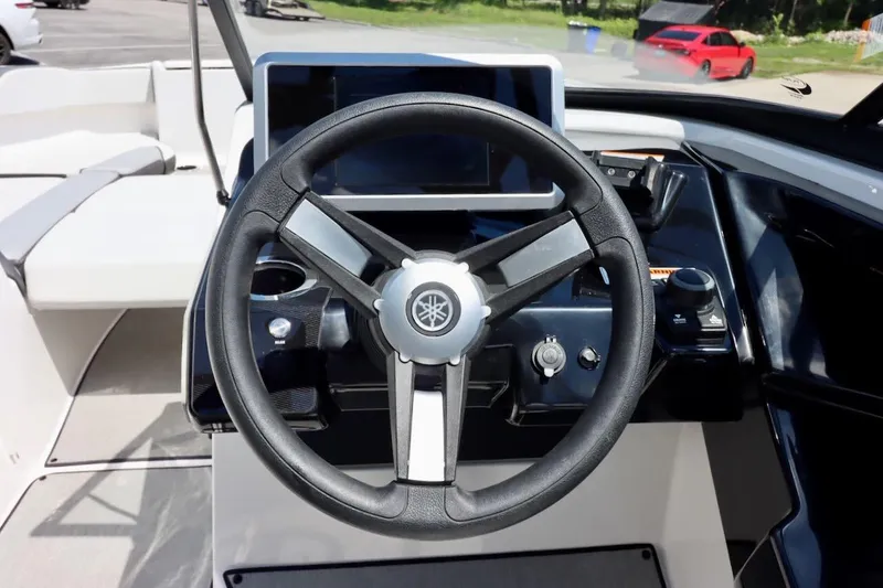 Slide: The Image of Steering wheel of 2023 Yamaha Boats AR250, featuring modern dashboard controls. - 13
