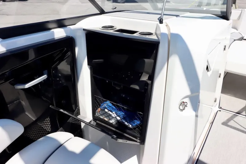 Slide: The Image of 2023 Yamaha AR250 boat interior storage compartment with open door and visible contents. - 16