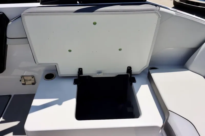 Slide: The Image of 2023 Yamaha AR250 boat storage compartment with open lid, showcasing interior space. - 25