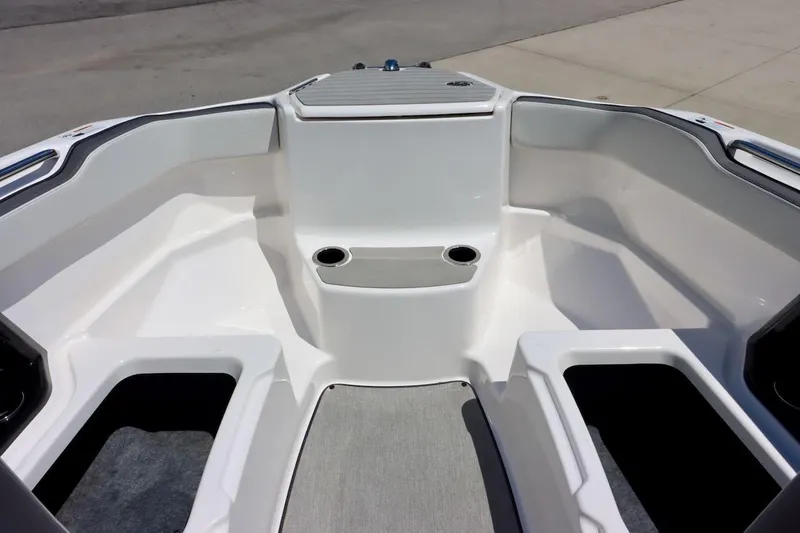 Slide: The Image of 2023 Yamaha Boats AR250 bow seating area with cup holders and storage compartments. - 26