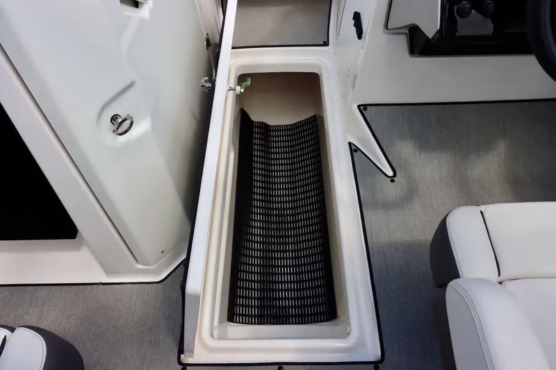 Slide: The Image of 2023 Yamaha Boats AR250 storage compartment with open hatch and black mat. - 29