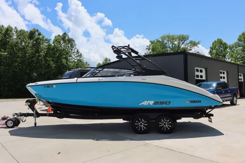 Slide: The Image of 2023 Yamaha Boats AR250 in blue, parked on a trailer outdoors. - 3