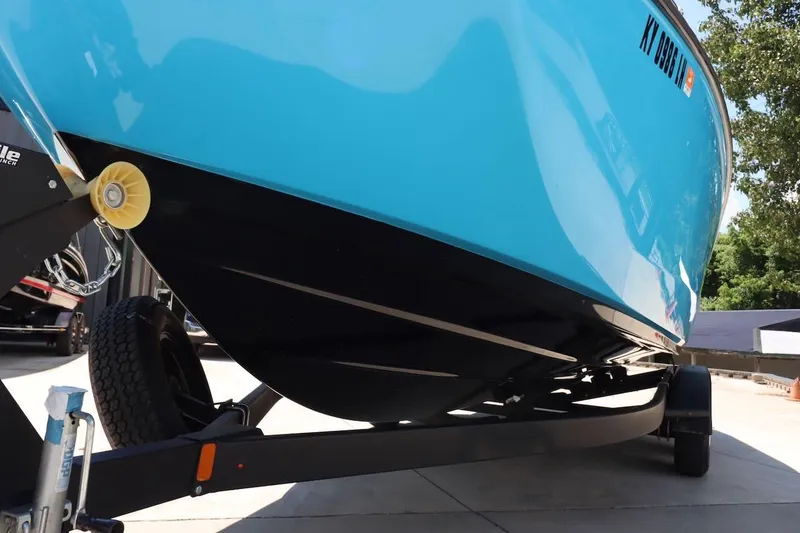 Slide: The Image of 2023 Yamaha Boats AR250 in blue on a trailer, side view. - 32