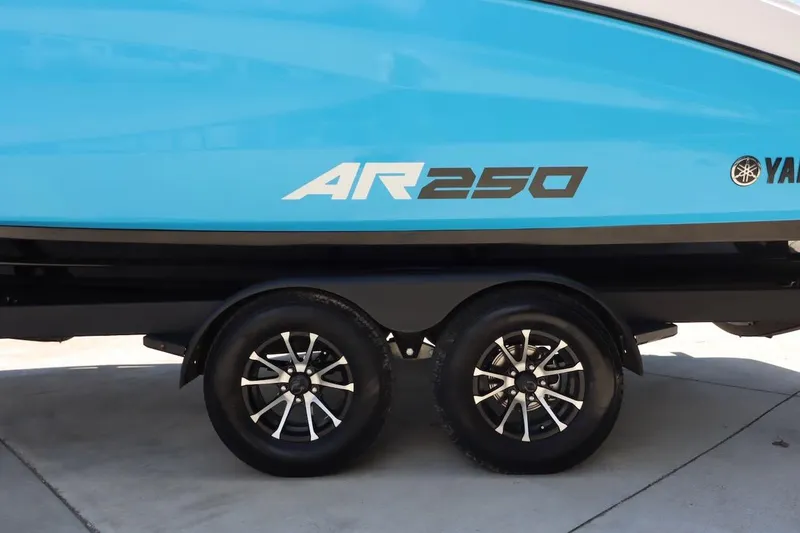 Slide: The Image of 2023 Yamaha AR250 boat on trailer, featuring sleek blue design and dual wheels. - 35