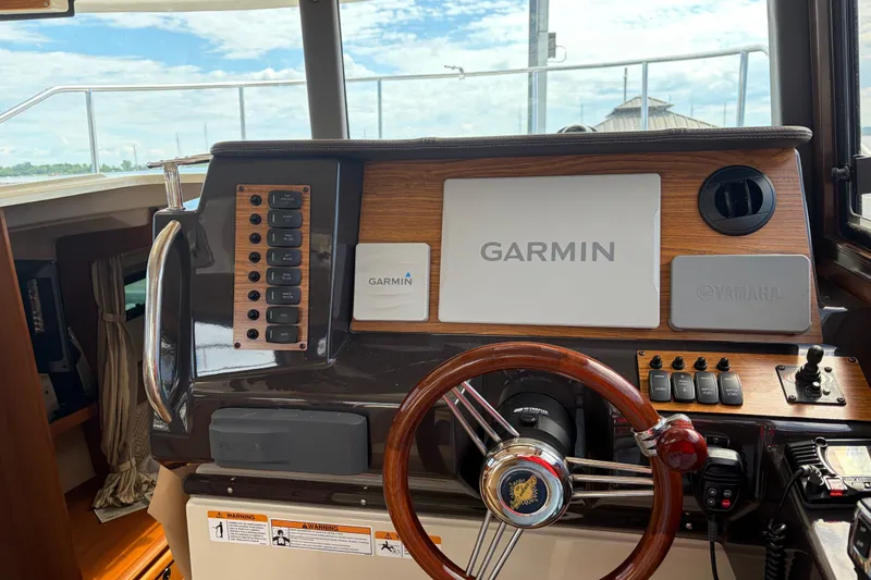 Slide: The Image of 2022 Ranger Tugs R-27 helm with Garmin navigation and Yamaha controls. - 2