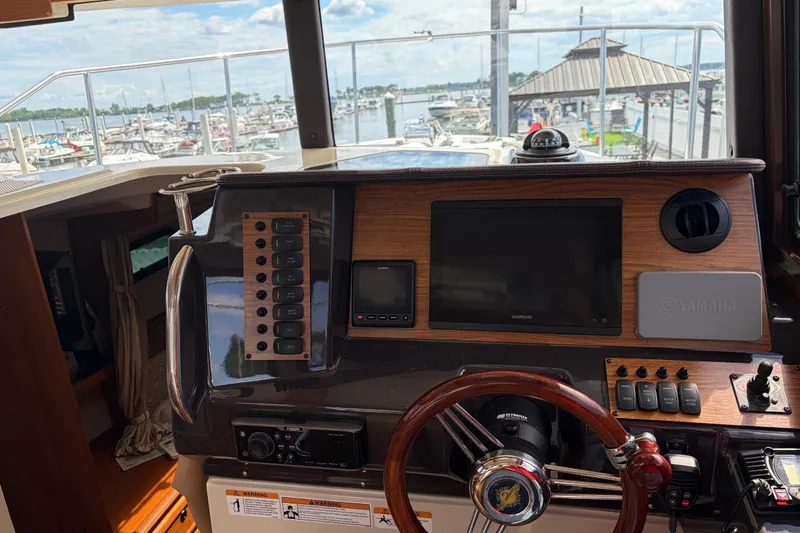 Slide: The Image of 2022 Ranger Tugs R-27 helm with navigation controls and marina view. - 3