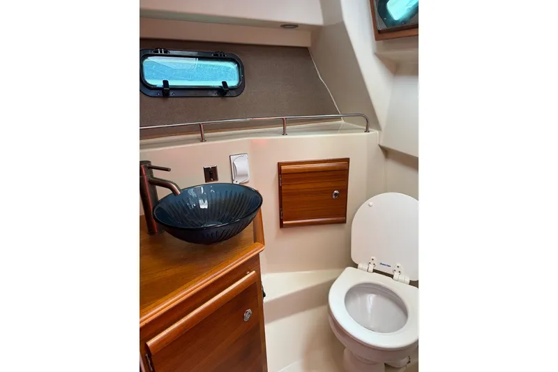 Slide: The Image of 2022 Ranger Tugs R-27 boat bathroom with modern sink and toilet. - 5