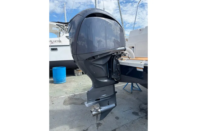 Slide: The Image of 2022 Ranger Tugs R-27 outboard motor, docked, with blue sky background. - 9