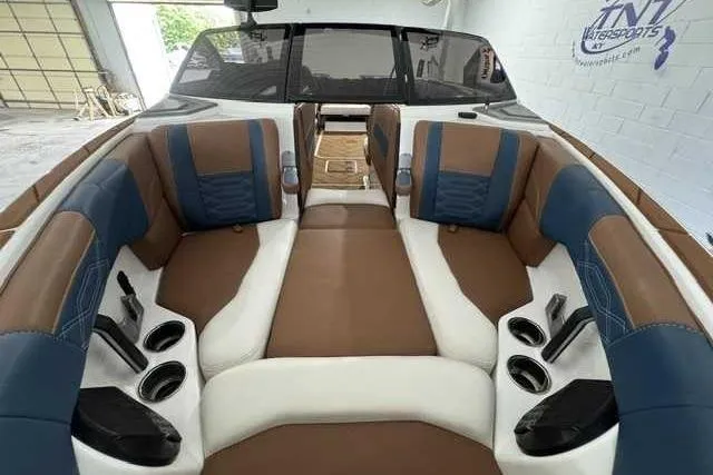 Slide: The Image of 2023 Malibu Wakesetter 25 LSV interior with brown and blue seating, cup holders, and sleek design. - 8