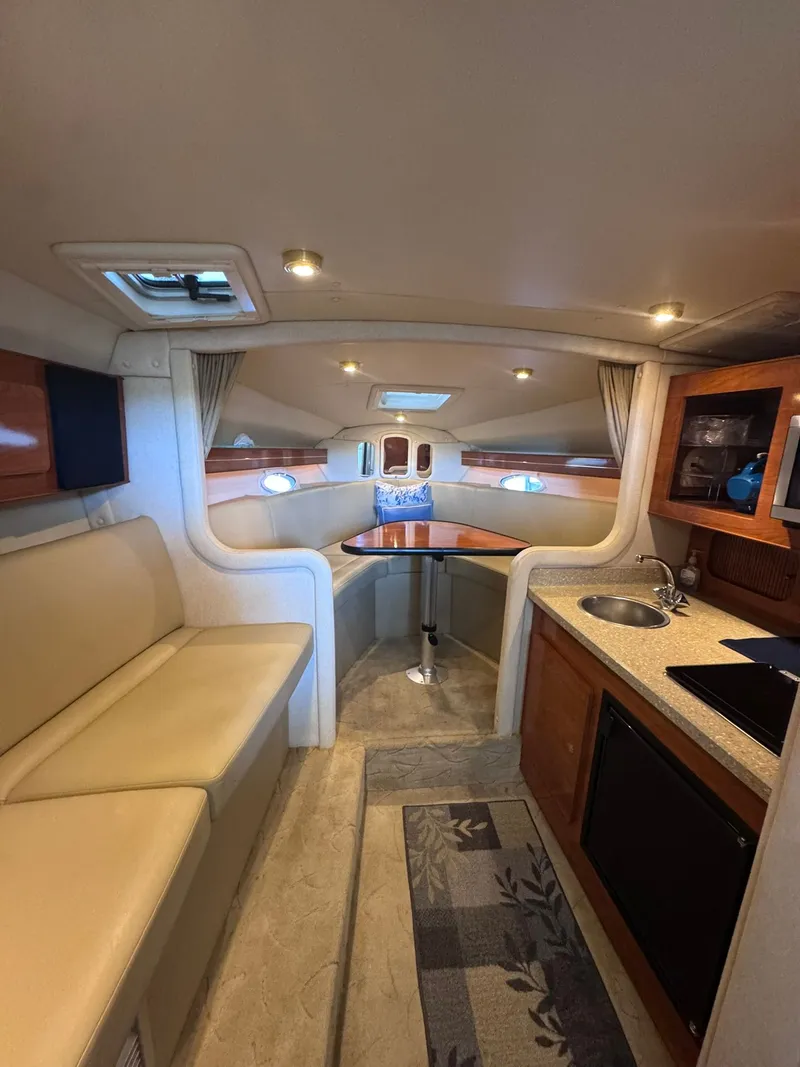 Slide: The Image of Interior of a 2006 Rinker Fiesta Vee 300 yacht with kitchen and seating area. - 18