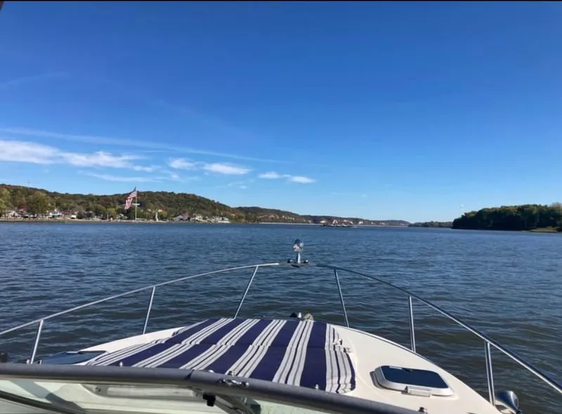 Slide: The Image of Rinker Fiesta Vee 300 boat on calm lake, blue sky. - 8