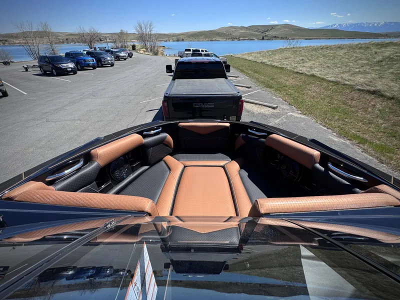 Slide: The Image of Interior of a 2026 Supreme S240 boat with brown seats by the lake. - 15