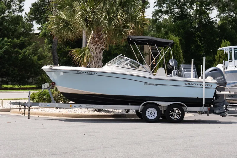 The Image of 2017 Grady-White Freedom 205 boat on trailer, parked near palm trees. - 1