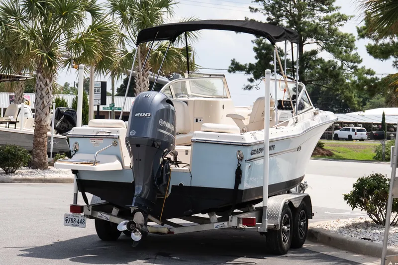 Slide: The Image of 2017 Grady-White Freedom 205 boat on trailer with Yamaha engine, parked near palm trees. - 6