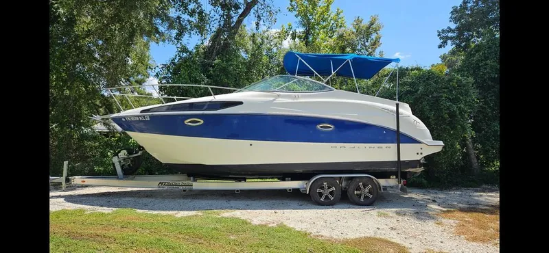 The Image of 2006 Bayliner 265 boat parked on trailer outdoors. - 0
