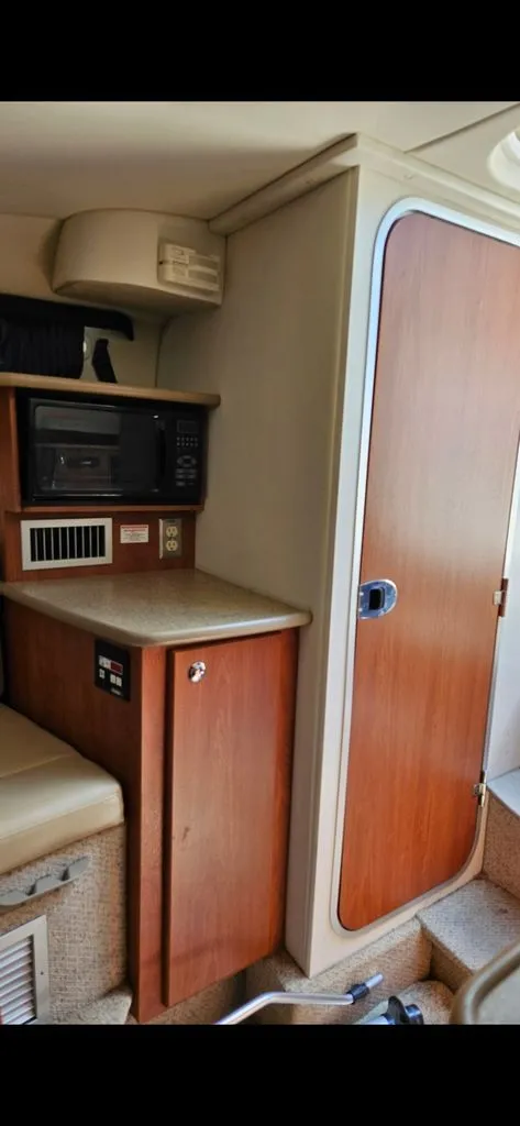 Slide: The Image of Interior of a 2006 Bayliner 265 with microwave and wooden cabinets. - 5