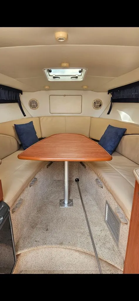 Slide: The Image of Interior of a 2006 Bayliner 265 with table and seating area. - 6